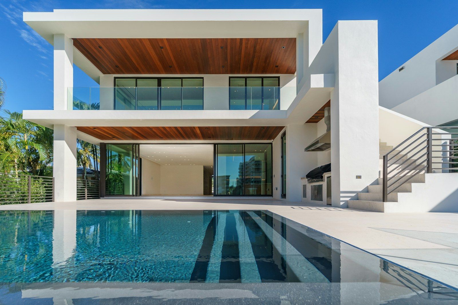 Casa branca com piscina, beiral em madeira e varanda integrada (imagem meramente ilustrativa, não é obra do escritório)
